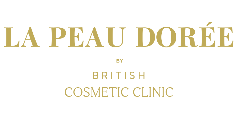 Gold serif text on a white background reading 'LA PEAU DORÉE' with smaller text below reading 'BY BRITISH COSMETIC CLINIC'.